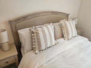 a bed with white sheets and pillows on it at Cardiff Mini Retreat in Cardiff