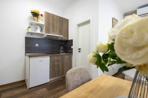 a kitchen with a table with a vase of flowers at Split Varos Inn in Split