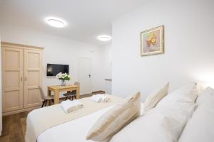 a bedroom with two beds and a table with a tv at Split Varos Inn in Split