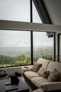 a living room with a couch in front of a large window at Villa Gaia Novi Grad in Jablanica +4 photos