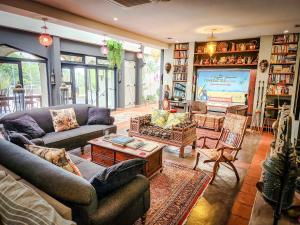 a living room with couches and a flat screen tv at Le Chemin Guesthouse - 6 sleeper in Kloof