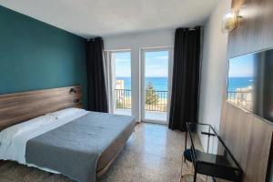 a bedroom with a bed and a view of the ocean at Hotel OCTOPUS in Can Picafort
