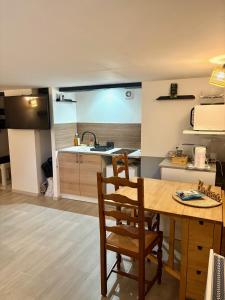 a kitchen with a wooden table and chairs and a sink at Flat ADB in Maintenon