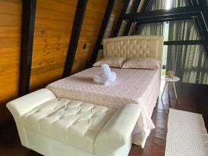 a bed with a teddy bear sitting on top of it at Romantic nature retreat | Hot tub and fireplace in São Pedro de Alcântara