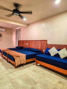 a bedroom with two beds and a ceiling fan at Family Studio Suite with Kitchenette & Terrace - Santuario Hotel Boutique in Chemuyil +58 photos