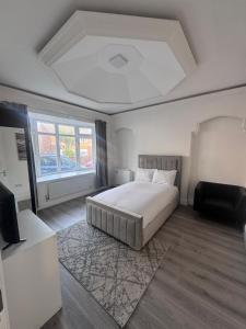 a white bedroom with a bed and a window at The Villas in Rock Ferry