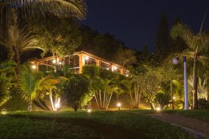 a house lit up at night with lights at Pousada Vale do Dinossauro in São Pedro