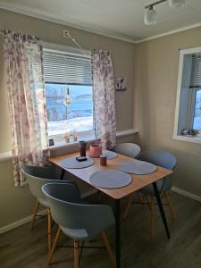 a dining room with a table and chairs and a window at Lyngen apartment in Lyngseidet