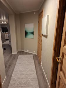 an empty hallway with a door and a painting on the wall at Lyngen apartment in Lyngseidet +5 photos