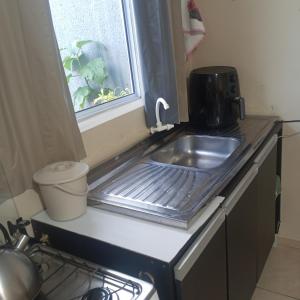 a kitchen counter with a sink and a window at Microcasa na região do lago in Cascavel +10 photos