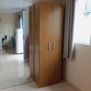a wooden cabinet in a room with a kitchen at Microcasa na região do lago in Cascavel