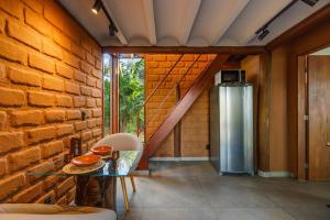 a kitchen with a table and a brick wall at Chalé com hidro em meio a natureza in Brasília