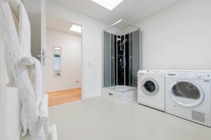 a white laundry room with a washer and dryer at Orange Suite Schliengen 2 in Schliengen