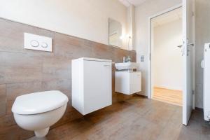 a bathroom with a white toilet and a sink at Orange Suite Schliengen 2 in Schliengen +13 photos
