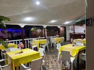 a dining room with yellow tables and white chairs at Hotel Santa Barbara in Arauca