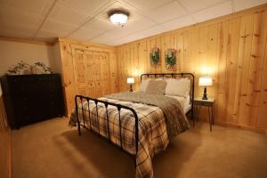 a bedroom with a bed in a room with wooden walls at Big Arbor Pines Family friendly in Woodruff