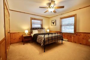 a bedroom with a bed and a ceiling fan at Big Arbor Pines Family friendly in Woodruff