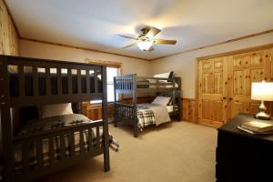 a bedroom with two bunk beds and a ceiling fan at Big Arbor Pines Family friendly in Woodruff
