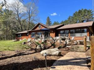 a log home with a landscaping of rocks in front of it at Big Arbor Pines Family friendly in Woodruff +28 photos
