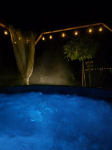 a large pool of blue water at night at Leśna Osada -Dominikowo -sauna , balia in Dominikowo +79 photos