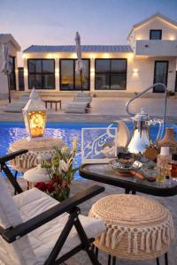 a patio with a table and chairs next to a pool at Deem view in Al Ain