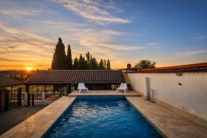a swimming pool with two chairs in front of a house at heart & ponie - Retiro Rural Privado con Piscinas in Chinchón