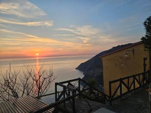 a sunset over a body of water with a building at Agave di mare in Riomaggiore