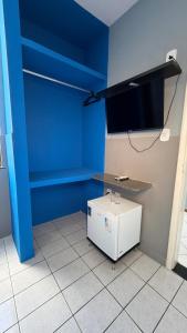 a room with a blue wall and a white refrigerator at Hotel Brasilia in Aracaju +19 photos