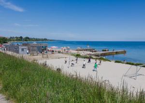 a group of people playing on a beach near the ocean at Lejlighed ved stranden og centrum in Fredericia