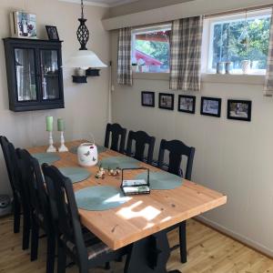 a dining room table with black chairs around it at Flott hytte - Enhus, Kråkerøy in Fredrikstad