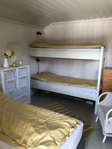 a room with two bunk beds and a table at Flott hytte - Enhus, Kråkerøy in Fredrikstad