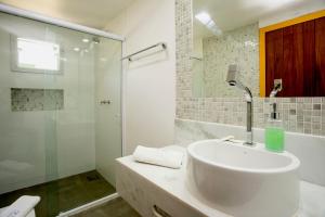 a white bathroom with a sink and a shower at Bliss Hotéis Concept in Búzios