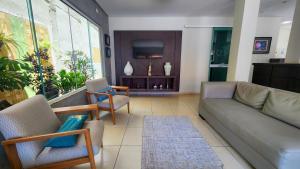a living room with a couch and chairs at Hotel Pousada Calliandra in Bonito