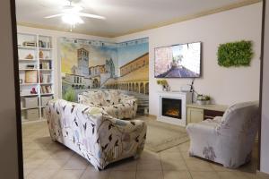a living room with two chairs and a fireplace at VILLA PATTY ASSISI con SPA e Piscina in Assisi +138 photos