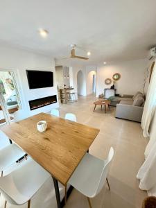 a living room with a wooden table and white chairs at Villa Paz in El Campello