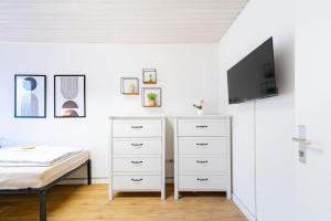 a bedroom with a bed and a tv on a wall at Orange Suite Schliengen 1 in Schliengen