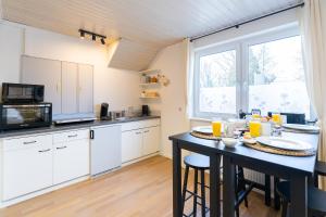 a kitchen with white cabinets and a large window at Orange Suite Schliengen 1 in Schliengen