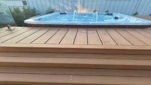 a hot tub sitting on top of a wooden deck at The Haven - Ettalong in Ettalong Beach