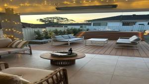 a patio with couches and a table and a fire place at The Haven - Ettalong in Ettalong Beach +13 photos