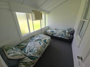 a small room with two beds and a window at Horseshoe House - Gympie in Gympie