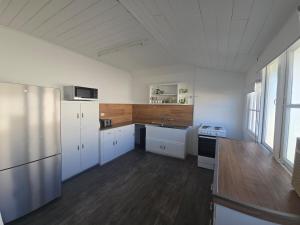 a kitchen with white cabinets and a wooden floor at Horseshoe House - Gympie in Gympie
