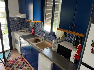 a small kitchen with blue cabinets and a sink at Sofia's house in Possidi +52 photos