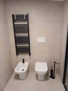 a bathroom with a white toilet and a sink at Bovisa home in Milan