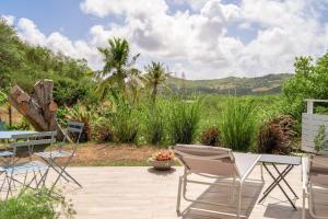 a patio with a table and chairs and a field at LODGE LE Filaos in Sainte-Anne