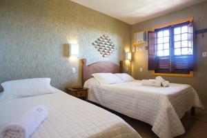 a hotel room with two beds and a window at Bliss Hotéis Concept in Búzios