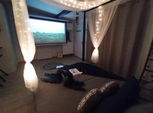 a teddy bear laying on a bed in front of a television at A l'Orée des pins - Gite et spa de 30 m2- Options Home Cinéma, Romantique in Cuges-les-Pins