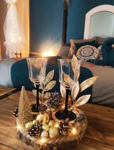 two wine glasses on a table in a bedroom at A l'Orée des pins - Gite et spa de 30 m2- Options Home Cinéma, Romantique in Cuges-les-Pins +19 photos