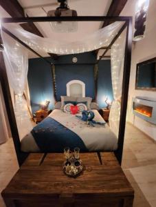a bedroom with a canopy bed with a wooden table at A l'Orée des pins - Gite et spa de 30 m2- Options Home Cinéma, Romantique in Cuges-les-Pins