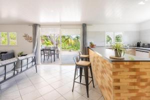 a kitchen and living room with a counter and a table at LODGE LE Filaos in Sainte-Anne