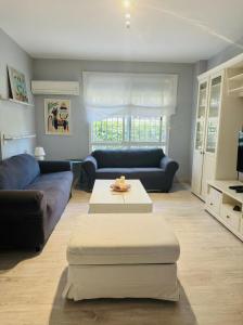 a living room with two couches and a coffee table at Sevilla Family House - La casa de Marta in Montequinto